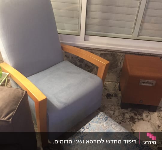 כורסה מרופדת עם הדום מרופד ליד שולחן קטן